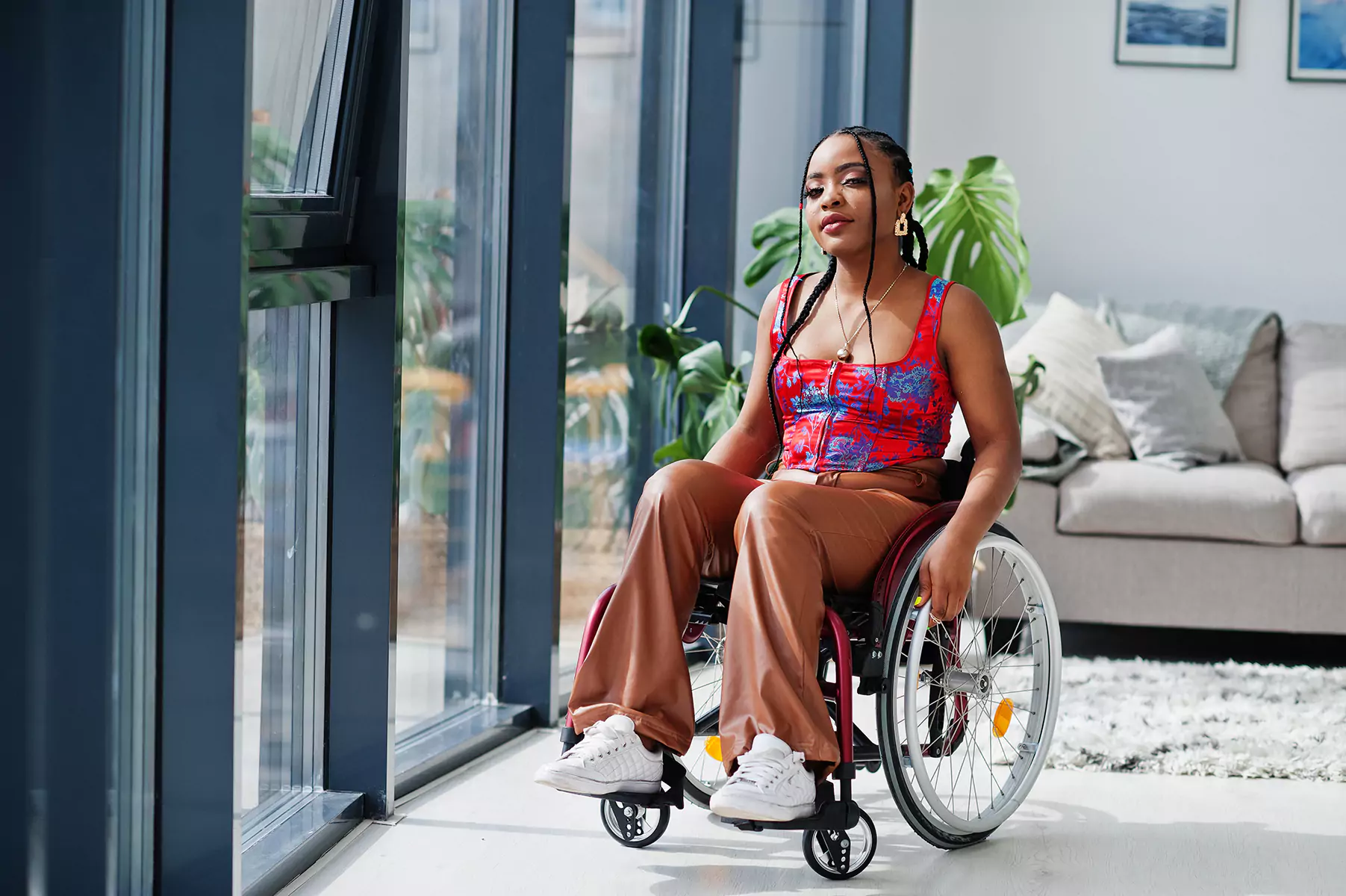 Disabled woman in wheelchair sitting in lounge room and smiling at camera