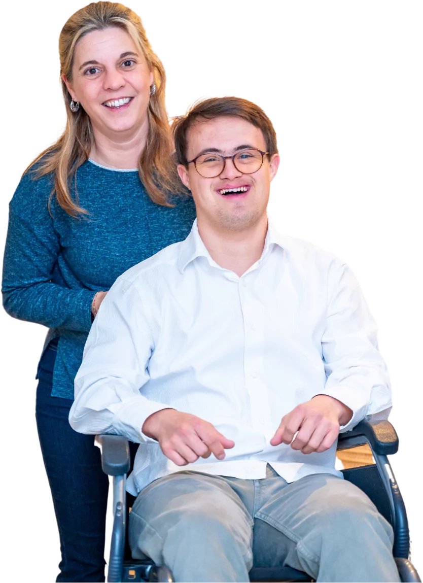 Disabled man with down syndrome smiling at camera with support worker behind him